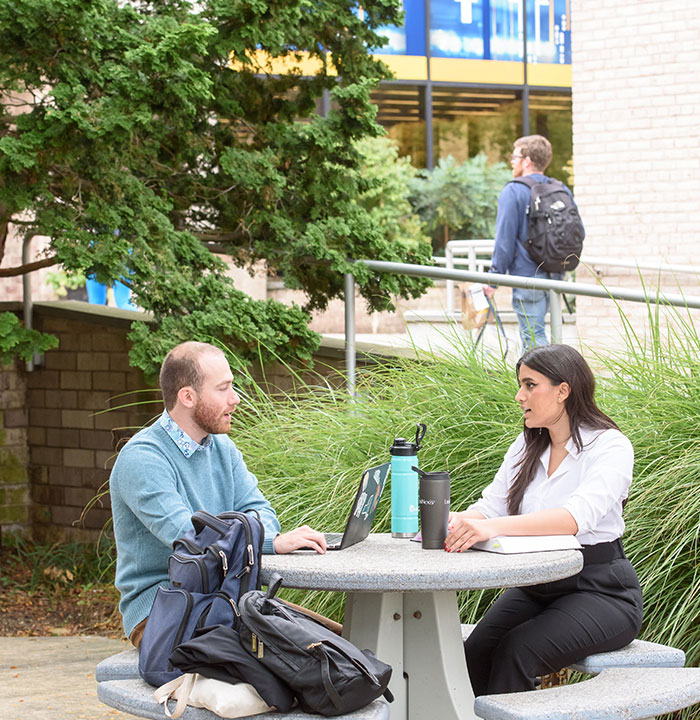 Four Students Talking Together Outside on Campus