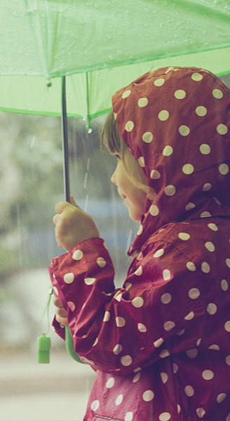 Child Holding an Umbrella in the Rain