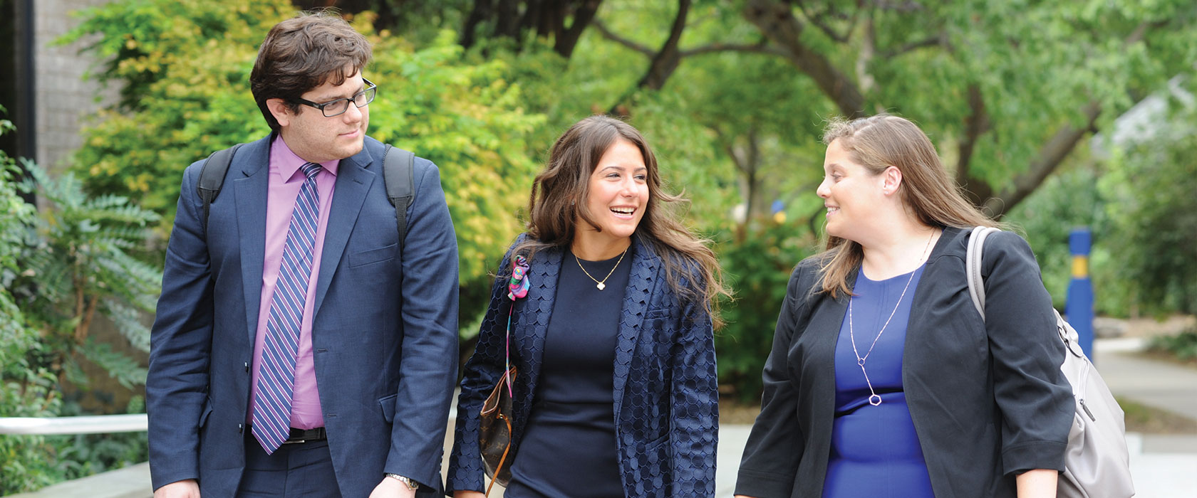 Three students walking together on campus. 